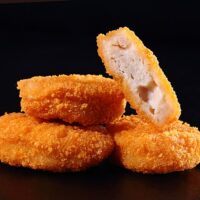 A pile of chicken nuggets isolated on black color background